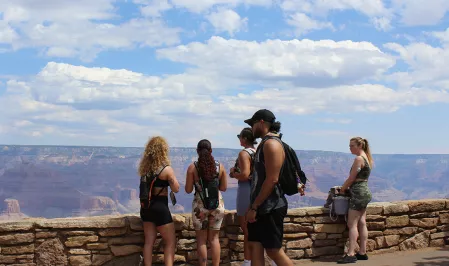eine Gruppe junger Menschen steht vor dem Grand Canyon. Eine Frau trägt einen CGM-Sensor