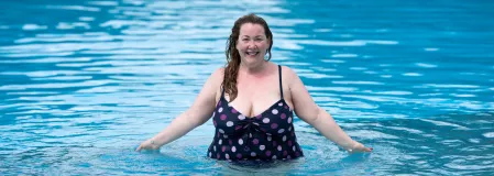 Fröhliche übergewichtige Frau im Swimmingpool