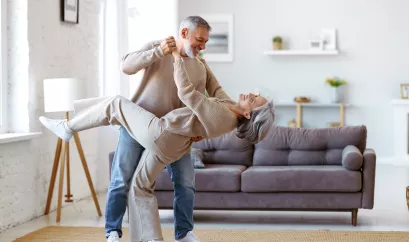 Tanzendes älteres Paar im Wohnzimmer