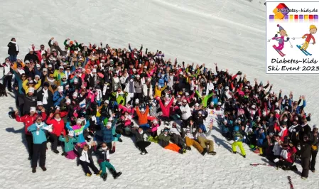 Eine große Gruppe Kinder und Erwachsener auf einer Skipiste. Sie tragen Ski- bzw. Schneekleidung und recken die Hände in die Höhe. Das Bild wurde auf dem Ski Event 2023 aufgenommen