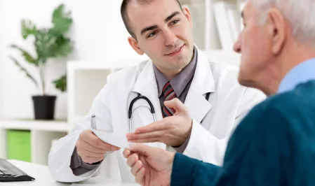 Arzt erläutert seinem Patienten ein Rezept