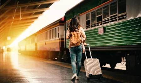 Frau mit Koffer am Bahnsteig