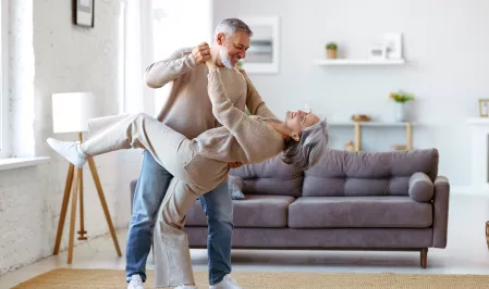 Tanzendes älteres Paar im Wohnzimmer