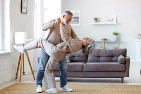 Tanzendes älteres Paar im Wohnzimmer