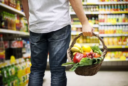 Mann beim Einkaufen mit Korb Mann beim Einkaufen mit Korb