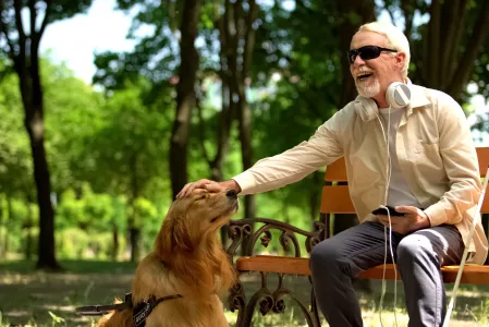 Mann mit Sehbehinderung und Assistenzhund Mann mit Sehbehinderung und Assistenzhund
