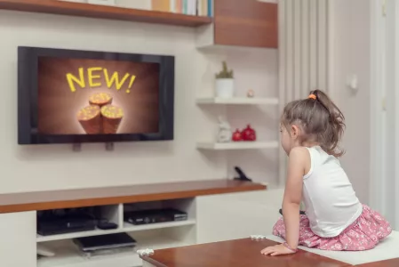 Kind sieht Süßigkeitenwerbung im Fernsehen Kind sieht Süßigkeitenwerbung im Fernsehen