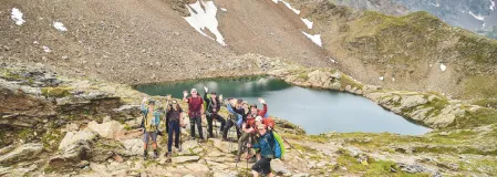 Eine Drohnenaufnahme von der Gruppe vor einem kleinen Bergsee