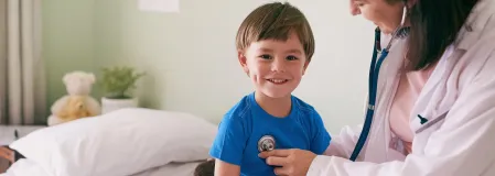 Junge bei Kinderdiabetologin Ärztin, die Junge mit Stethoskop untersucht