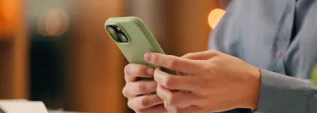 Frau mit Smartphone und Laptop beim Arbeiten