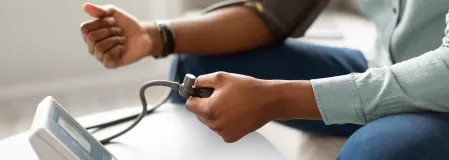 Mann misst Blutdruck mit Messger&auml;t