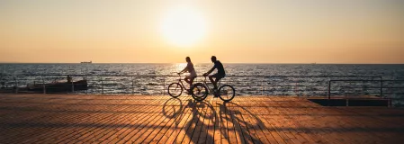 Mann und Frau beim Radfahren am Meer Mann und Frau beim Radfahren am Meer