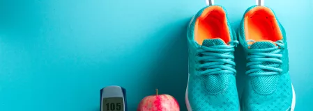 Laufschuhe, Apfel und Blutzuckermessgerät