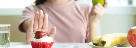 Frau isst Obst statt Muffin Frau isst Obst statt Muffin
