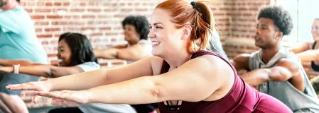 Sport in der Gruppe Eine diverse Gruppe Menschen macht Sport. Sie tragen Sportkleidung und machen gerade eine Kniebeuge