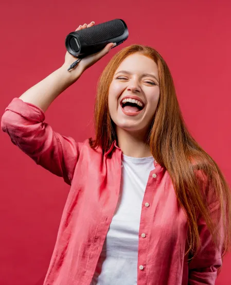 Junge Frau mit Lautsprecher in der Hand Junge Frau mit Lautsprecher in der Hand