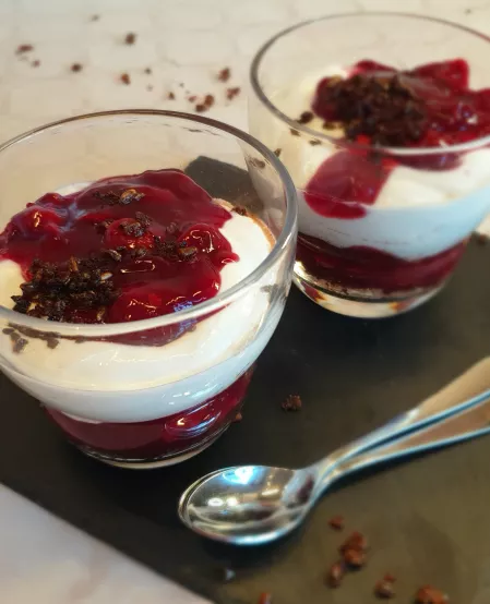 Schwarzwälder Kirsch-Dessert Das Schwarzwälder Kirsch-Dessert ist in zwei Gläser geschichtet, unten dunkle Pumpernickelbrösel, dann Kirschkompott, darüber Quark und oben etwas Kompott garniert mit etwas Brösel.