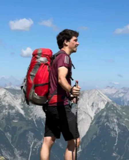 Ivo Rettig mit Wanderrucksack in den Bergen
