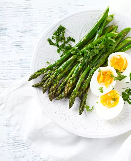 Spargelsalat mit Ei Gebratener grüner Spargel und halbe Eier garniert mit frischen Kräutern.