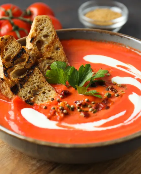 Tomatensuppe mit etwas Sahne und Petersilie garniert, dazu getoastetes Brot