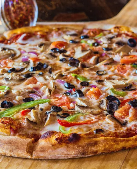 Vollkornpizza mit Paprika, Zwiebeln und Oliven 