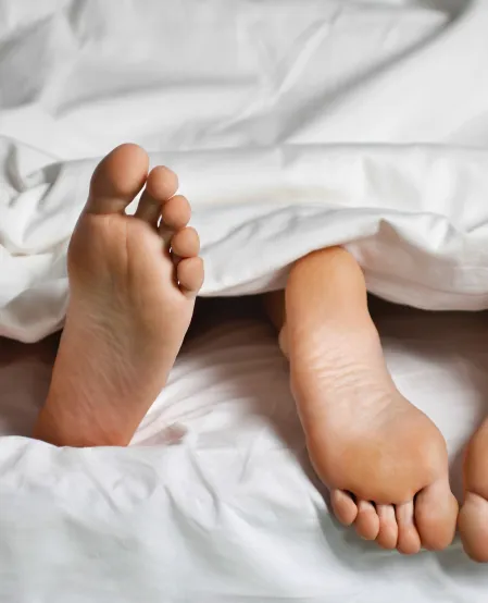 F&uuml;&szlig;e von Paar im Bett