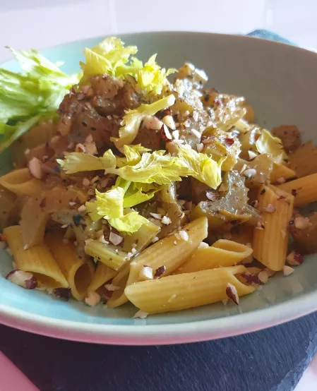 Pasta mit Staudensellerie Penne mit Stangensellerie, garniert mit dessen Blattgrün und gehackten Haselnüssen