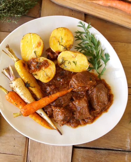 Wildschweinpfeffer mit bunten Wurzeln und Kartoffeln aus dem Ofen Wildschweinpfeffer mit bunten Wurzeln und Kartoffeln aus dem Ofen