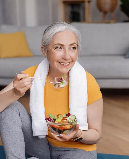 Ältere sportliche Frau isst Salat Ältere sportliche Frau isst Salat