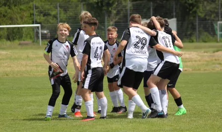 FC Diabetes auf dem Fußballplatz Das Fußballteam FC Diabetes feiert auf dem Fußballplatz. Sie tragen schwarz-weiße Trikots