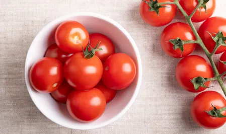 Tomaten in einer Schüssel und an einer Rispe