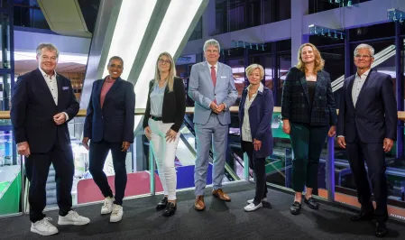 Ein Gruppenbild des Vorstands von diabetesDE vor einem dunklen Hintergrund mit Lichtern