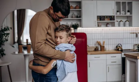 Sohn mit Typ-1-Diabetes umarmt seinen Vater
