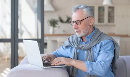 Älterer Mann beim Webinar Älterer Mann beim Webinar
