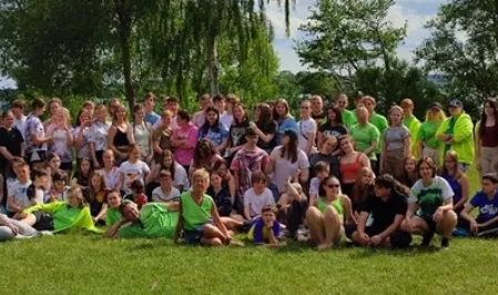 Pfingstcamp Eine Gruppe Jugendlicher im Grünen. Einige Teamer*innen tragen grüne Shirts.