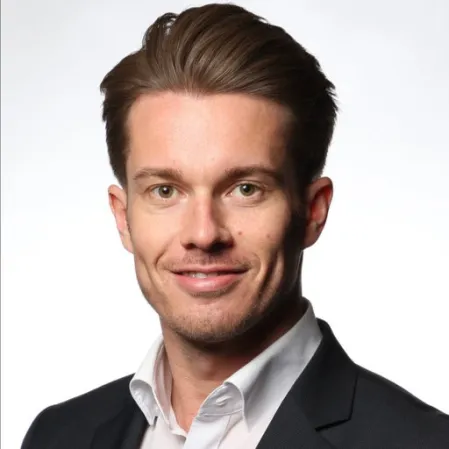 Prof. Dr. Othmar Moser l&auml;chelt freundlich in die Kamera. Seine Haare sind leicht gegelt nach hinten gelegt, er tr&auml;gt einen Anzug und ein wei&szlig;es Hemd. 