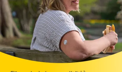 Frau sitzt auf einer Bank im Sonnenschein, an ihrem Arm ein FreeStyle Libre 3 Sensor