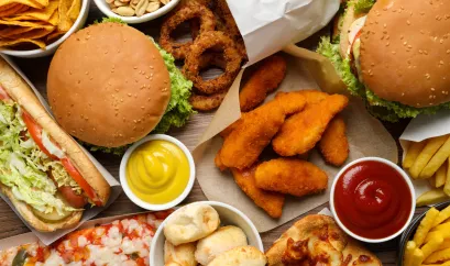 Unterschiedliche hoch verarbeitete Lebensmittel: Burger, Pizza, Nuggets, Zwiebelringe, Pommes etc.