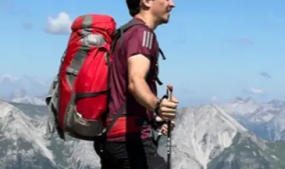Ivo Rettig mit Wanderrucksack in den Bergen