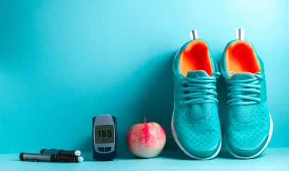 Laufschuhe, Apfel, Messgerät und Pen liegen vor türkisem Hintergrund