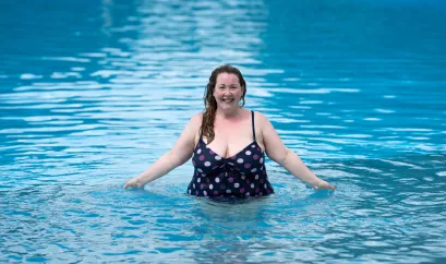 Fröhliche übergewichtige Frau im Swimmingpool