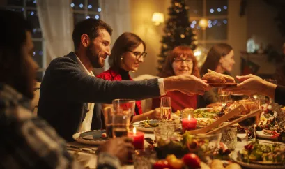 mehrere Menschen essen an einem feierlich gedeckten Tisch