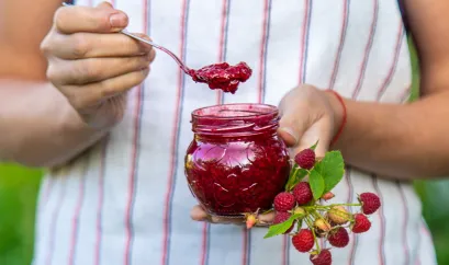 Ein Glas Himbeermarmelade und frische Himbeeren