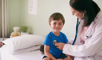 Ärztin, die Junge mit Stethoskop untersucht
