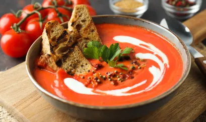 Tomatensuppe mit etwas Sahne und Petersilie garniert, dazu getoastetes Brot