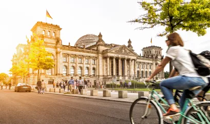 Frau auf Fahrrad vorm Reichstag in Berlin