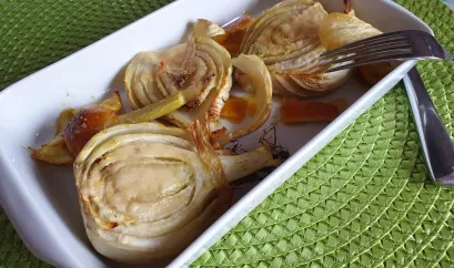 halbierte Fenchel in einer Auflaufform. Sie sind mit Käse überbacken