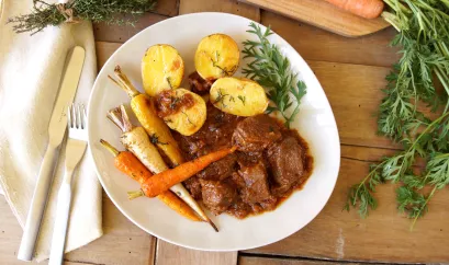 Wildschweinpfeffer mit bunten Wurzeln und Kartoffeln aus dem Ofen