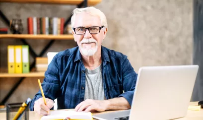 Älterer Mann recherchiert am Laptop