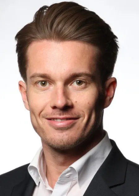 Prof. Dr. Othmar Moser l&auml;chelt freundlich in die Kamera. Seine Haare sind leicht gegelt nach hinten gelegt, er tr&auml;gt einen Anzug und ein wei&szlig;es Hemd. 